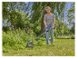 Een vrouw gebruikt een Gardena elektrische bosmaaier in haar tuin.