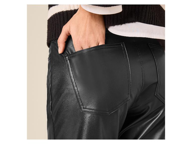 Close-up van een persoon in een zwarte kunstleren broek en een gestreepte trui.