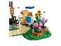 Een LEGO set met een imkerfiguur, bijenkorven en bloemen, met vliegende bijen.