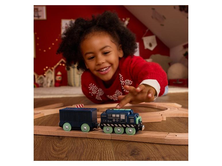 Lachend kind speelt met een speelgoedtrein op een houten spoor.