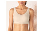 Een vrouw draagt een beige, naadloze bh van het merk Triumph.