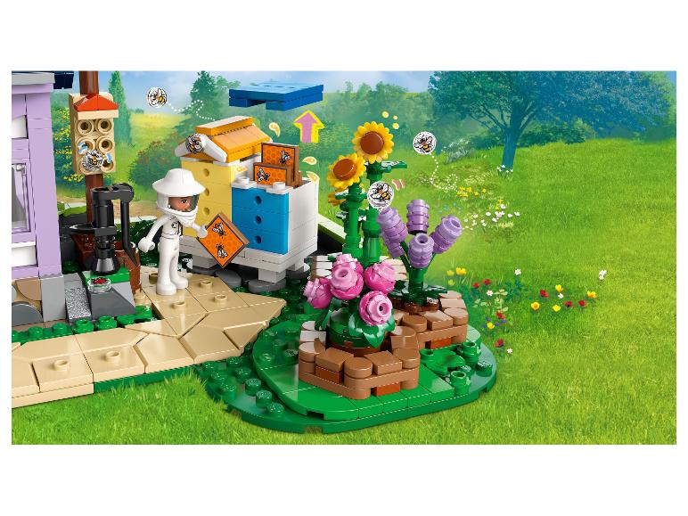 LEGO Friends set met imker, bijenkorven en bloemen in een groen landschap.