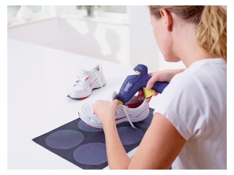 Vrouw gebruikt LIVARNO® lijmpistool om sneakers te lijmen.