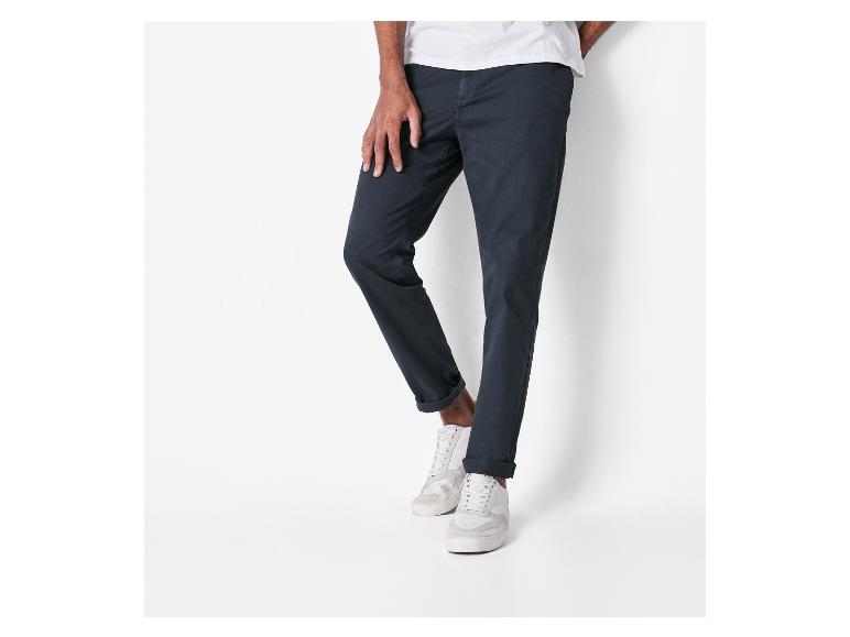 Donkerblauwe chino's en witte sneakers voor heren.