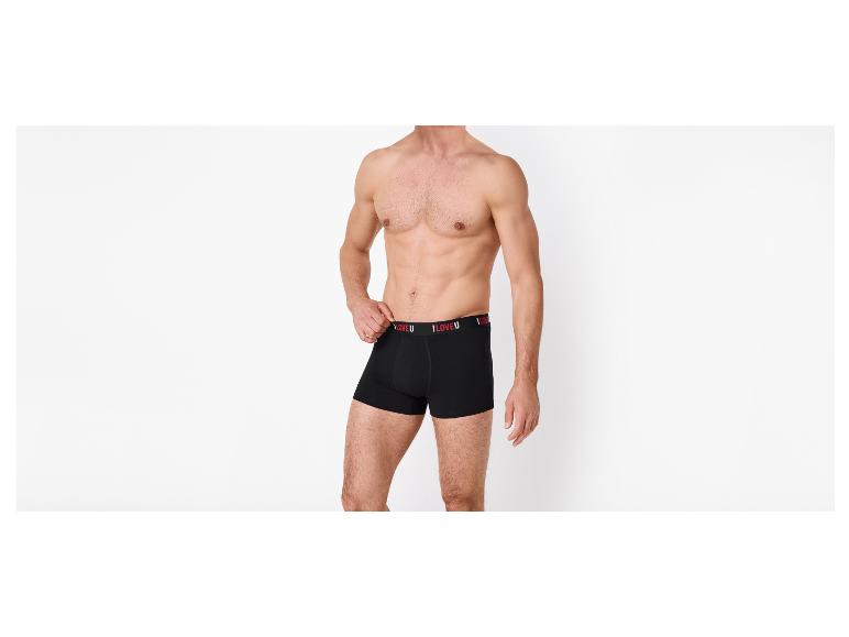 Man zonder shirt in zwarte boxershorts met de tekst 'I LOVE U' op de tailleband.