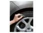 Hand die met een witte stift op een autoband schrijft