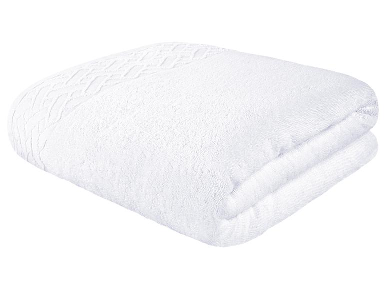 Een witte badhanddoek met een reliëfpatroon.