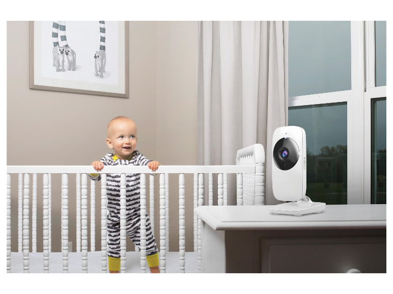 Een baby in een wieg en een babyfoon in de kinderkamer.