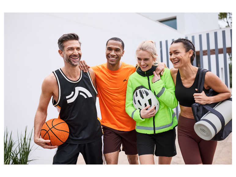 Vier vrienden lachen terwijl ze sportkleding en sportartikelen dragen.