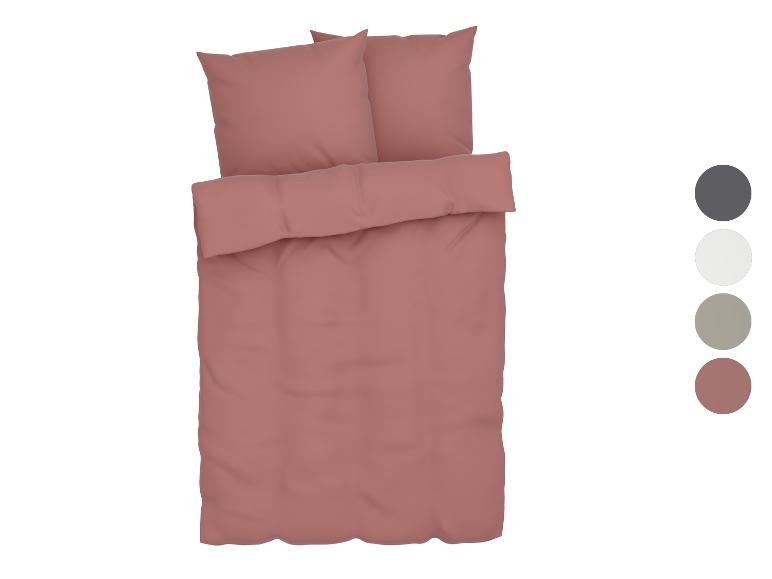 Stofrose beddengoedset met twee kussens en een lang kussen.