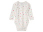 Witte baby romper met bloemen en hartjes print.