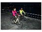 Twee mensen in CRIVIT thermo-hybride jassen fietsen 's nachts
