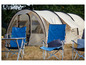 Campingstoelen en een tent op een grasveld.