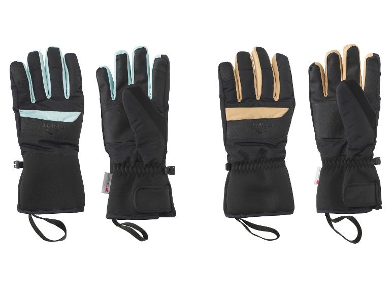 Vier zwarte en lichtblauwe/beige skihandschoenen, twee van voren en twee van achteren.