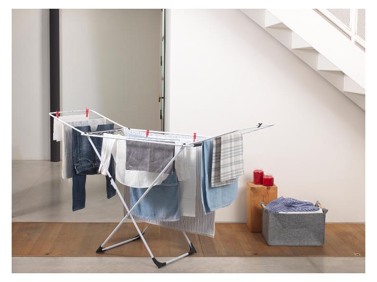 Wit wasrek met hangende was, wasmand en rode kaarsen.