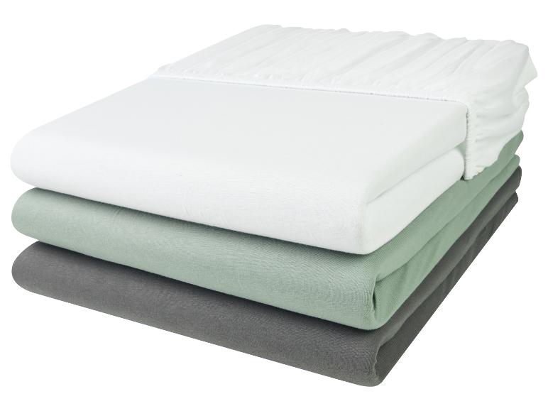 Een witte, groene en grijze hoeslakenset.