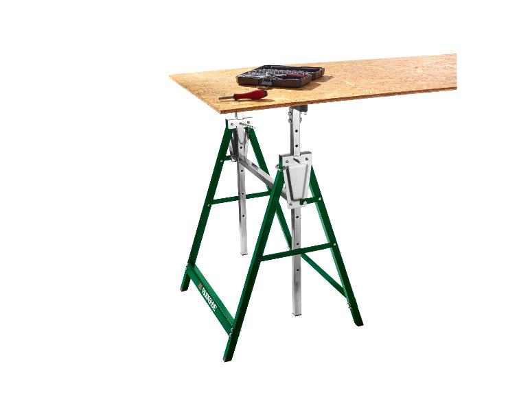 Opvouwbare werkbank met groene schragen, een houten blad en gereedschap erop.