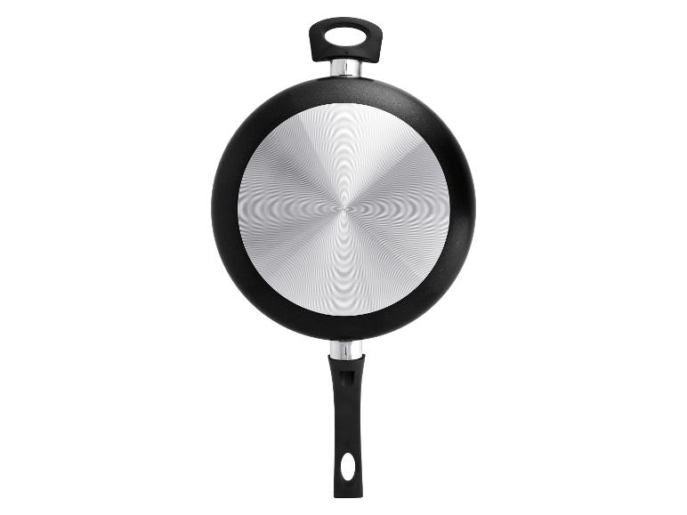 Zwarte koekenpan met een ronde metalen bodem, onderaanzicht.