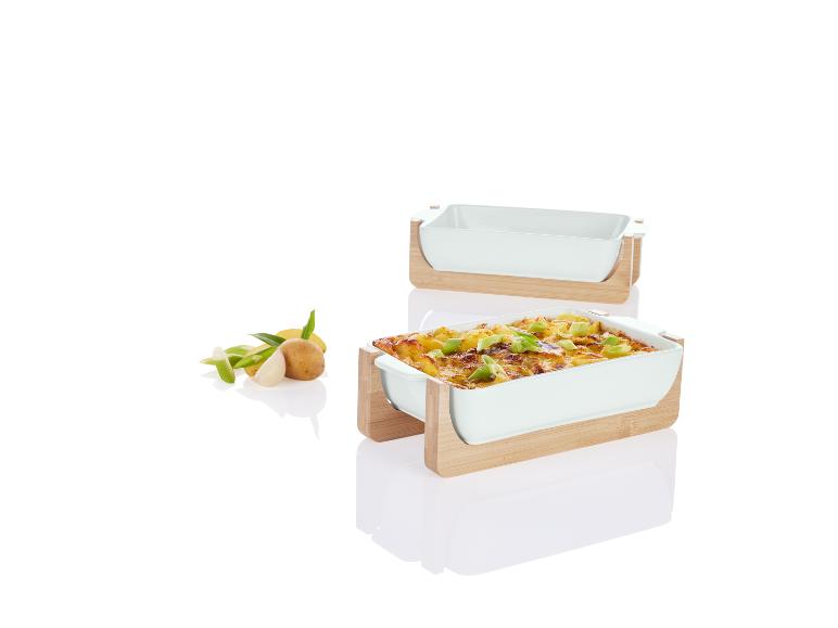 Witte keramische ovenschaal en serveerschaal op houten onderstel.