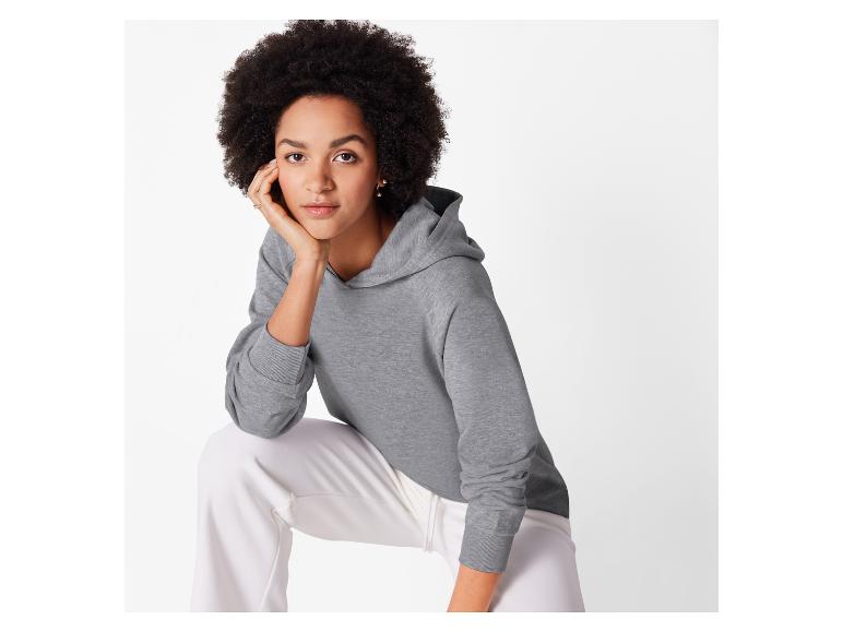 Grijze hoodie en witte broek.