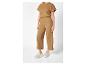 Camelkleurige jumpsuit en witte sneakers.