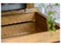 Houten opbergdoos of bloempot met planten op de achtergrond.