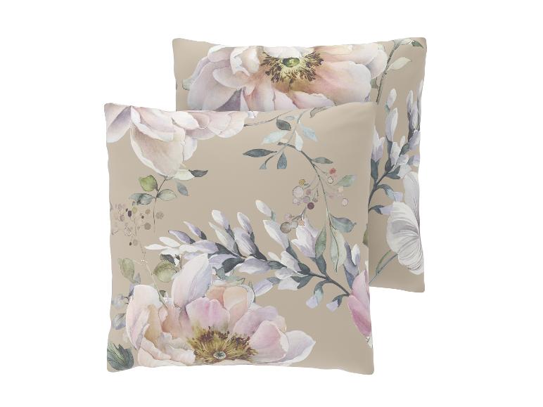 Twee beige decoratieve kussens met een delicaat bloemen aquarelpatroon.