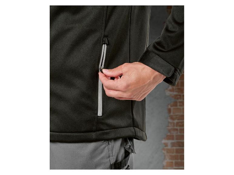 Close-up van een persoon die een zwarte jas dichtritst.