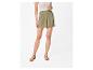 Olijfgroene shorts met hoge taille en minimalistische sandalen.
