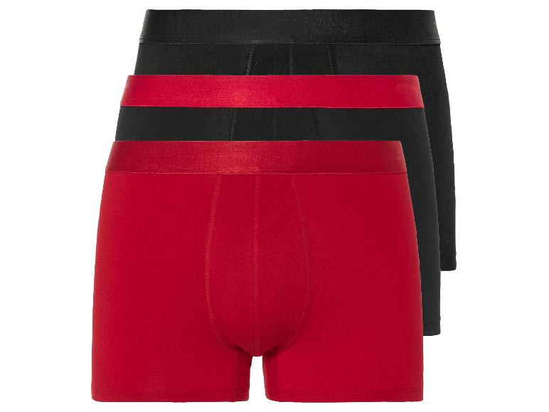 Drie boxershorts: één rood en twee zwart.