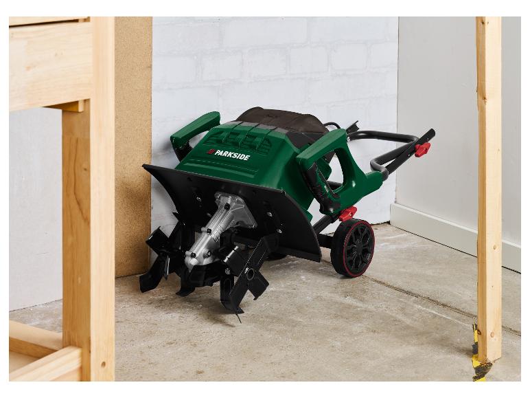 Groene Parkside elektrische grondfrees met wielen, op een betonnen vloer.