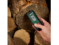 Digitale vochtmeter met display dat 0.0% en 22.9°C toont, vastgehouden op brandhout.
