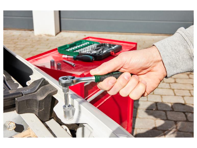 Een monteur gebruikt een Parkside ratel om een auto te repareren.