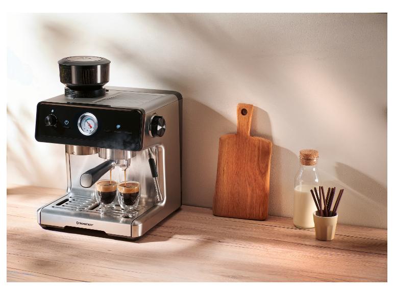 Espressomachine met geïntegreerde molen bereidt twee koffies, naast een melkfles en een snijplank.