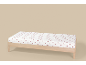 Wit hoeslaken met rode hartjes op een houten bed.