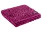 Gevouwen magenta handdoek met een gestructureerd patroon en een zwart label.