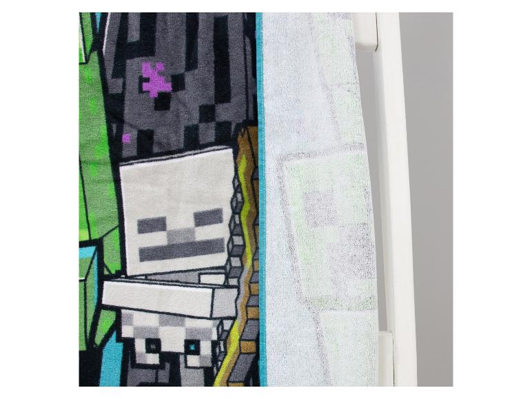 Badhanddoek met skeletontwerp en groene elementen, hangend aan een witte handdoekrek.