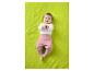 Baby in wit shirt met lange mouwen en roze broek liggend op een groene deken.