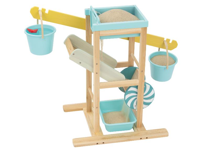 Houten zand- en waterspeelstation met emmers, zand, water en een rood papieren bootje.