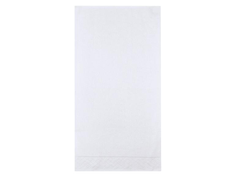 Witte handdoek met een subtiel patroon aan de onderkant.