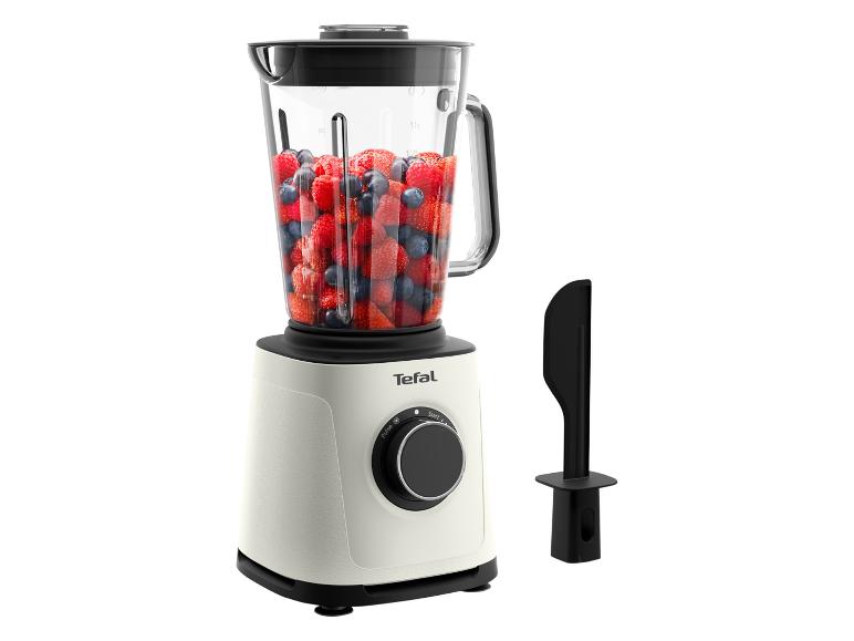 Blender met glazen kan gevuld met bosvruchten en een zwarte spatel.