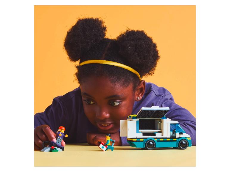 Kind speelt met LEGO: een busje en minifiguren.