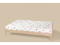Wit hoeslaken met rode strikpatronen op een houten bed.