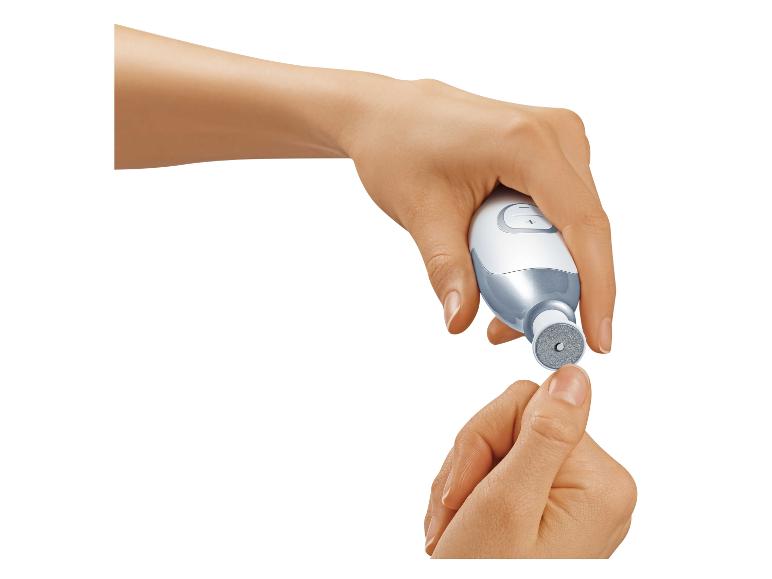 Twee handen gebruiken een elektrisch manicure-/pedicureapparaat.