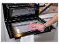 Vrouw maakt de binnenkant van een oven schoon met een doek, met de deur open en glas verwijderd.