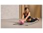 Een vrouw doet oefeningen met een roze fitnessbal van Crivit op een yoga mat.
