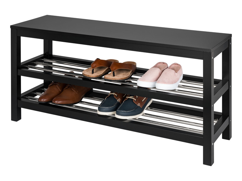 Een zwarte schoenenrek met drie niveaus, met daarop slippers, sneakers en herenschoenen.