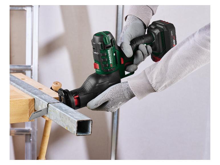 Gehandschoende man snijdt metalen pijp met een draadloze reciprozaag.