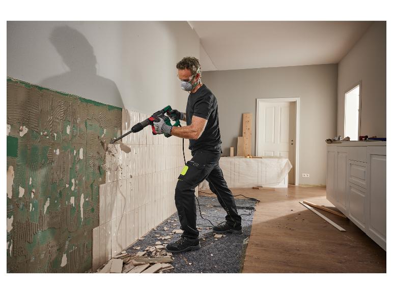 Een arbeider gebruikt een Parkside sloophamer om tegels te verwijderen.