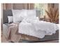 Slaapkamer met grijs bed, witte dekbedden en kussens, en een beige plaid.